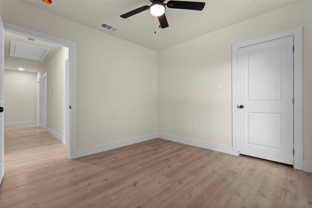 1104 S Brighton Avenue, Dallas, TX 75208 Wood-finish flooring, neutral wall tones, contrasting white trim, and a ceiling fan with integrated lighting