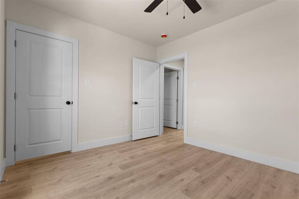 1104 S Brighton Avenue, Dallas, TX 75208 Light wood-finish flooring, neutral wall paint, white trim, and a ceiling fan