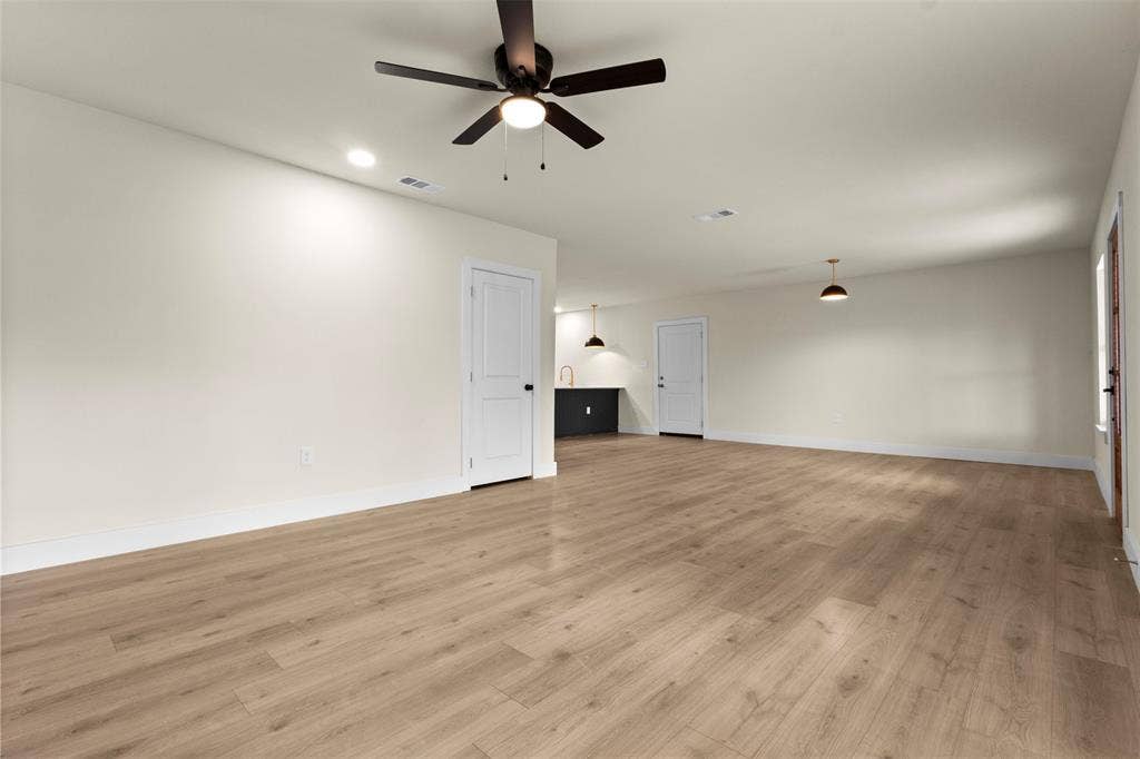 1104 S Brighton Avenue, Dallas, TX 75208 Spacious room featuring wood-finish flooring, recessed lighting, ceiling fan, and pendant lighting