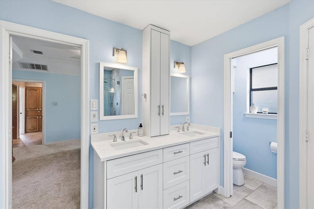 642 Eagle Drive, Coppell, TX 75019 Double sinks and tower storage. There is a pocket door to give some privacy to the toilet area. There is also additional storage over the toilet.
