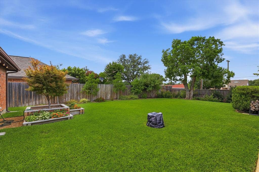 642 Eagle Drive, Coppell, TX 75019 Large backyard with landscaped beds and a place for the outdoor firepit. That is not a tree stump.