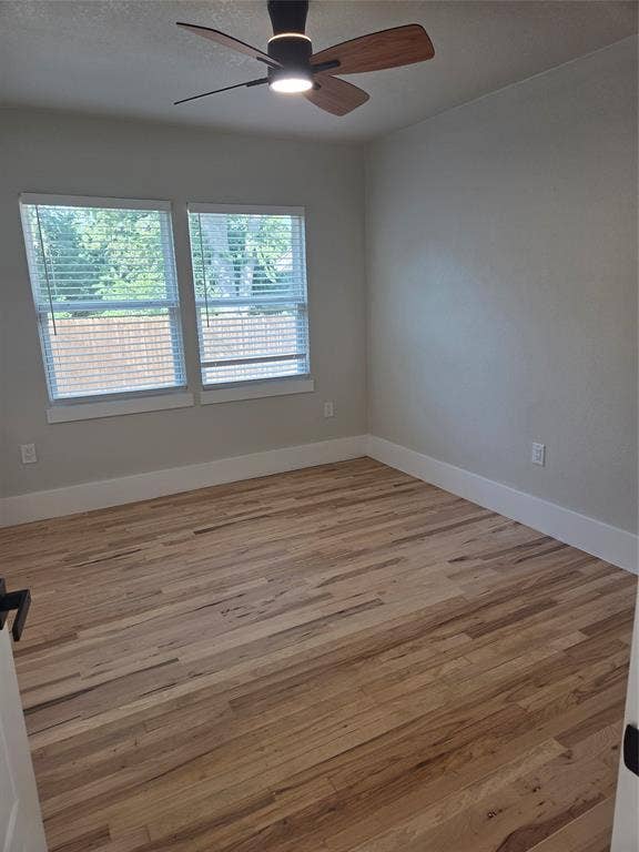 2329 Cass Street, Fort Worth, TX 76112 Spacious room featuring wood-finish flooring, white baseboards, and neutral wall tones