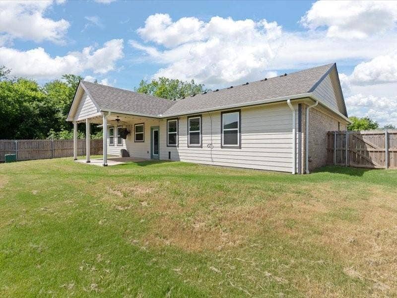 5528 Mesa Loop, Granbury, TX 76048 Expansive backyard featuring a covered patio, ceiling fan, and privacy fencing