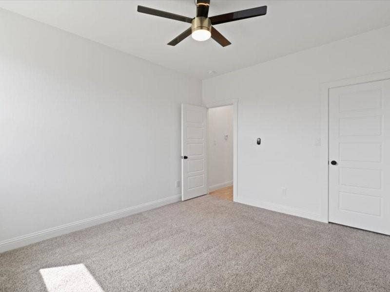 5528 Mesa Loop, Granbury, TX 76048 Spacious room featuring light gray carpet, white baseboards, and a modern ceiling fan with integrated lighting