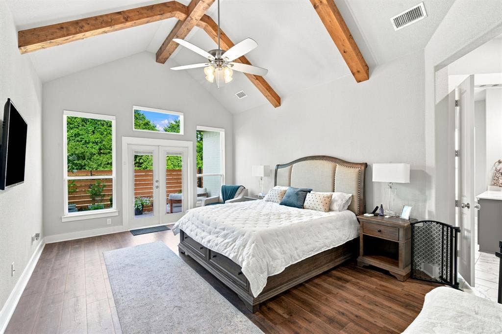 Vaulted ceiling with exposed wood beams and a ceiling fan