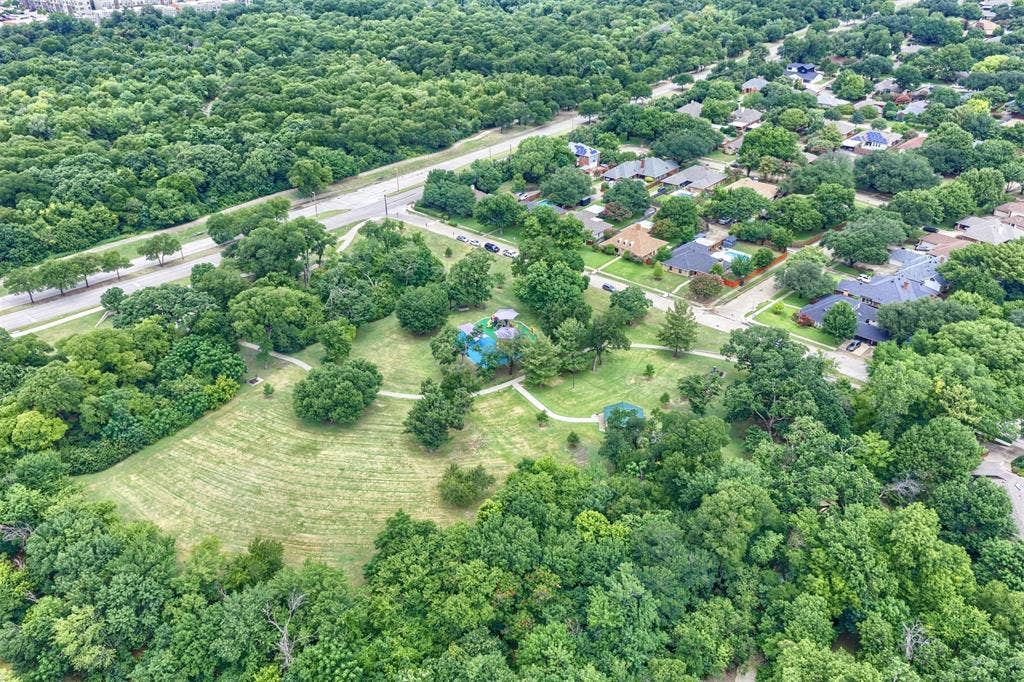 1717 Whitney Drive, Richardson, TX 75082 Aerial perspective showcasing a residential area surrounded by abundant mature trees and green spaces