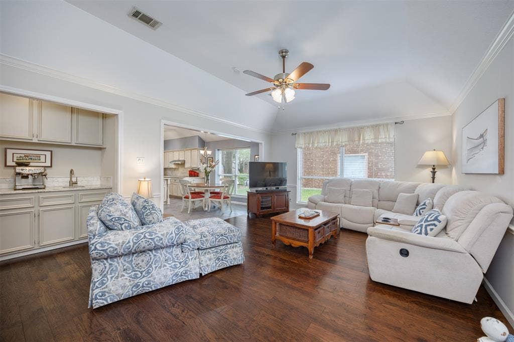 1717 Whitney Drive, Richardson, TX 75082 Living area featuring wood-finish flooring, vaulted ceiling, and a ceiling fan with light fixture