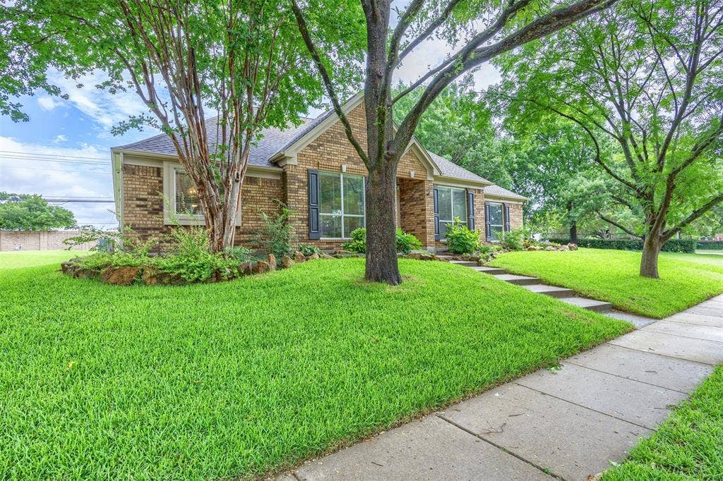 1717 Whitney Drive, Richardson, TX 75082 Brick exterior featuring dark shutters and a gabled roof