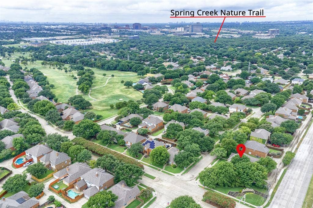 1717 Whitney Drive, Richardson, TX 75082 Aerial perspective showcasing a residential neighborhood with extensive tree canopies and a golf course