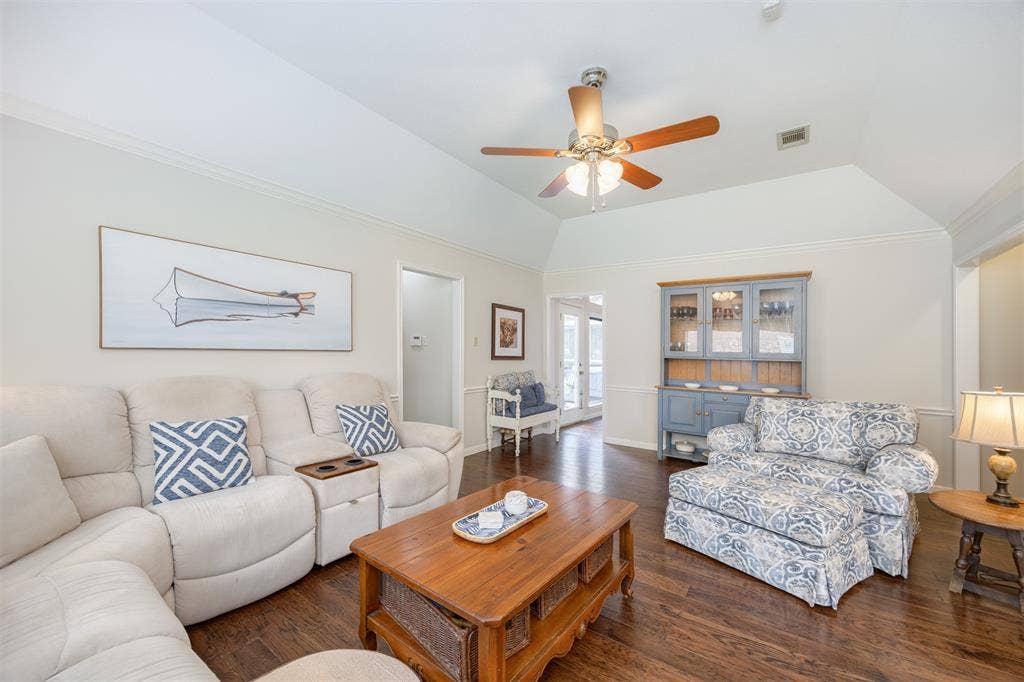 1717 Whitney Drive, Richardson, TX 75082 Spacious living area featuring vaulted ceilings, crown molding, wood-finish flooring, and a ceiling fan with integrated lighting