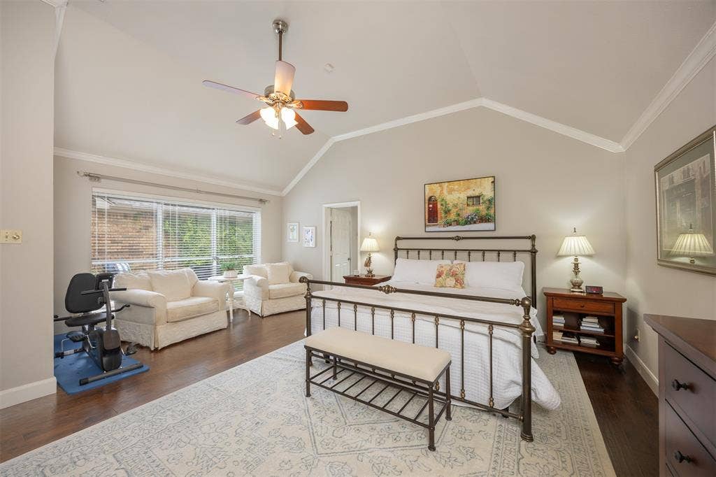 1717 Whitney Drive, Richardson, TX 75082 Spacious bedroom featuring vaulted ceilings, crown molding, wood-finish flooring, a ceiling fan, and large windows with blinds