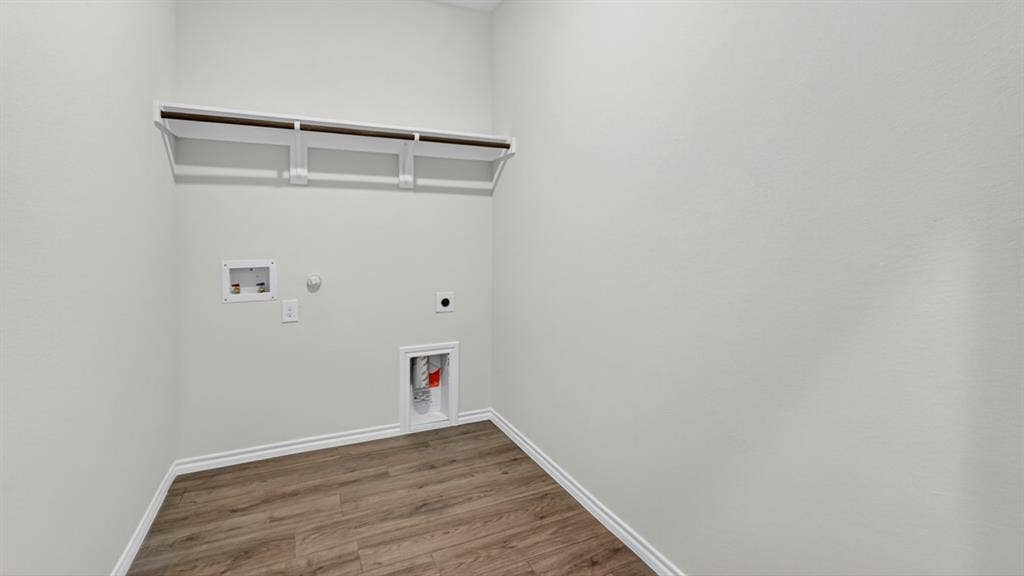 1933 Freeman Street, Tyler, TX 75704 Utility space featuring wood-finish flooring, light grey walls, and a built-in hanging rod with shelving