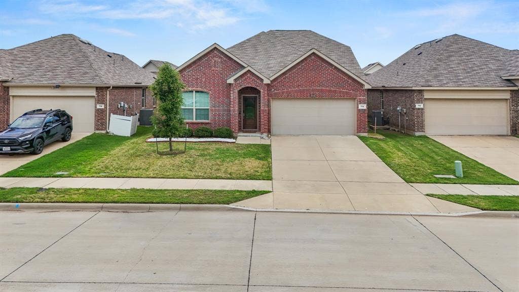 714 Stallings Drive, Princeton, TX 75407 Traditional brick exterior with a gabled roofline and attached two-car garage