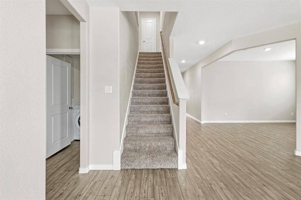714 Stallings Drive, Princeton, TX 75407 Carpeted staircase with white balusters and wood-finish handrail