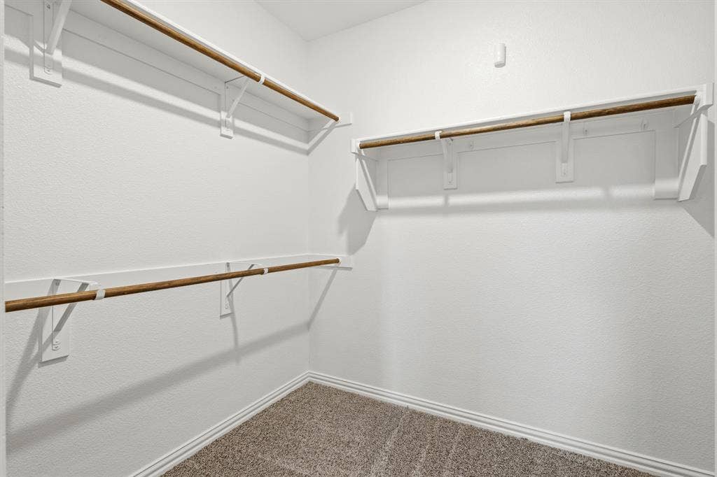 714 Stallings Drive, Princeton, TX 75407 Walk-in closet featuring white painted shelving and wood-finish hanging rods