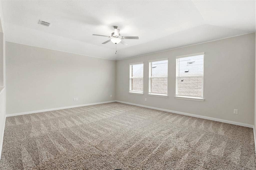 714 Stallings Drive, Princeton, TX 75407 Spacious room featuring neutral carpeting, light-toned walls, and a ceiling fan with integrated lighting