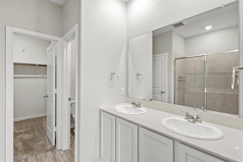 714 Stallings Drive, Princeton, TX 75407 Bathroom featuring a double vanity with white cabinetry and an integrated countertop with two undermount sinks