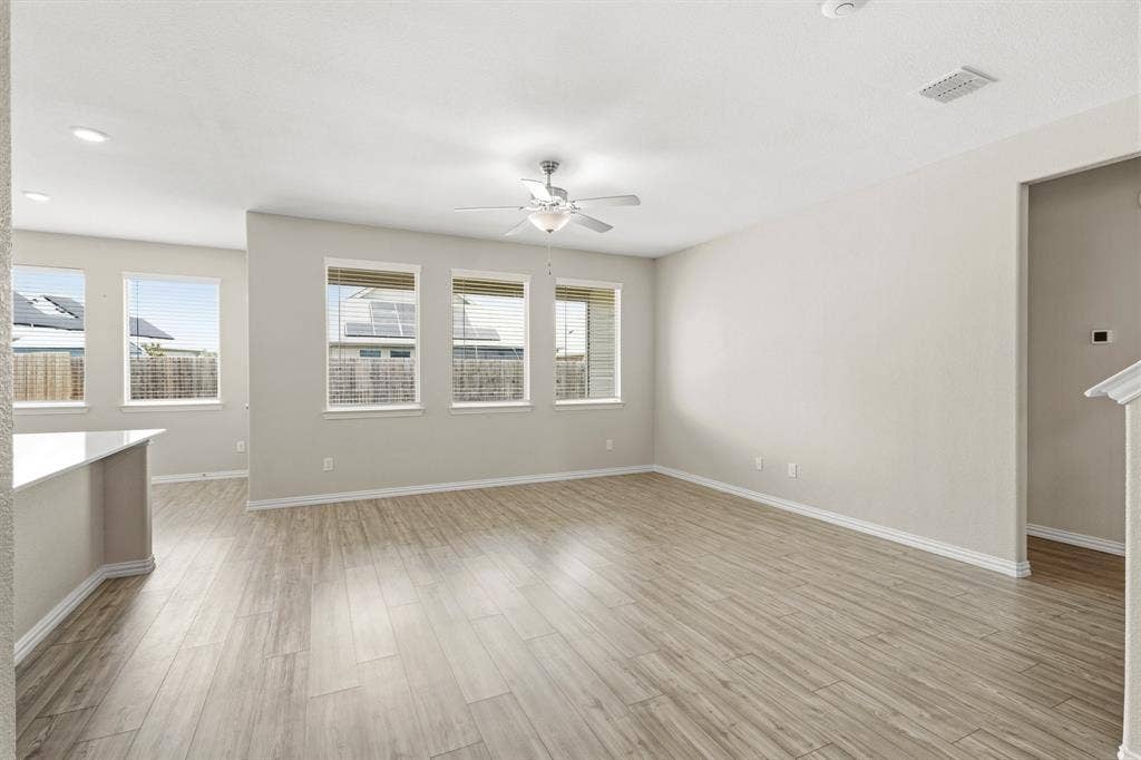 714 Stallings Drive, Princeton, TX 75407 Spacious living area featuring light wood-finish flooring, recessed lighting, and multiple windows with blinds