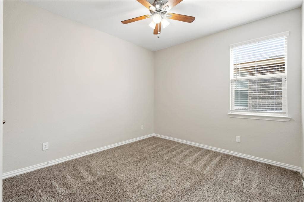714 Stallings Drive, Princeton, TX 75407 Carpeted interior room featuring a window with blinds, a ceiling fan with integrated lighting, light-toned walls, and white baseboards