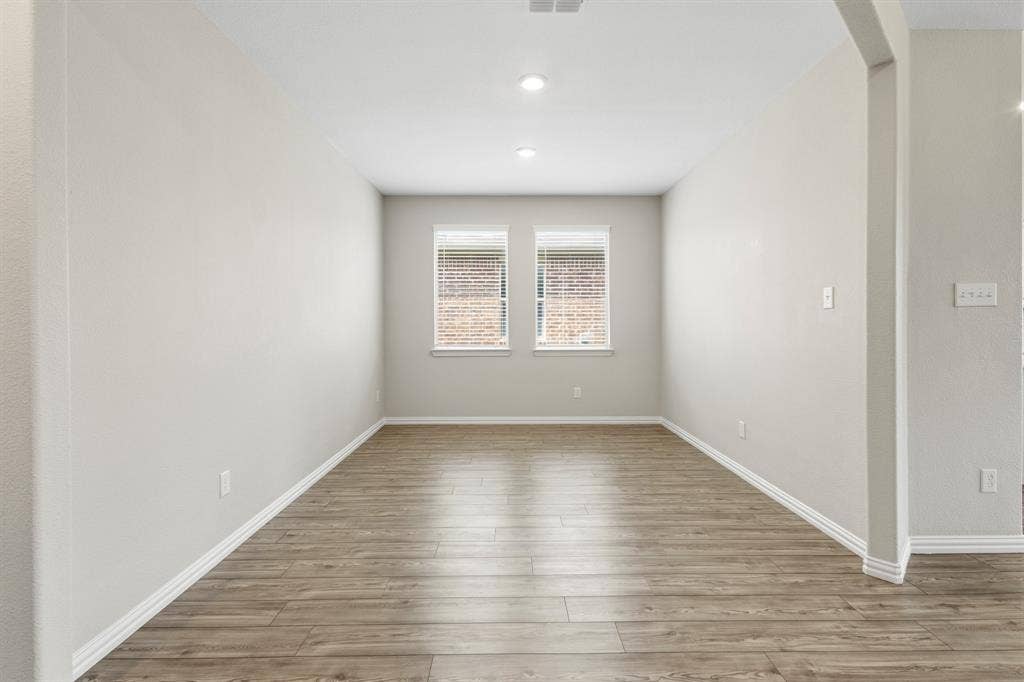 714 Stallings Drive, Princeton, TX 75407 Spacious interior room featuring wood-finish flooring, two windows with blinds, recessed lighting, and light-toned walls