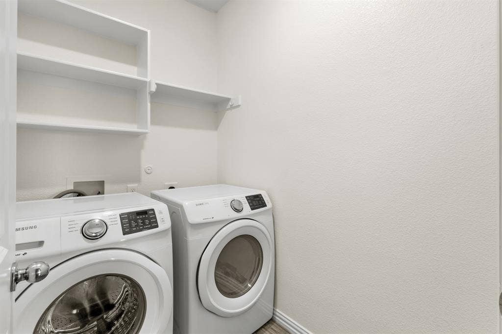 714 Stallings Drive, Princeton, TX 75407 Dedicated laundry area featuring white walls, ample built-in shelving, and wood-finish flooring
