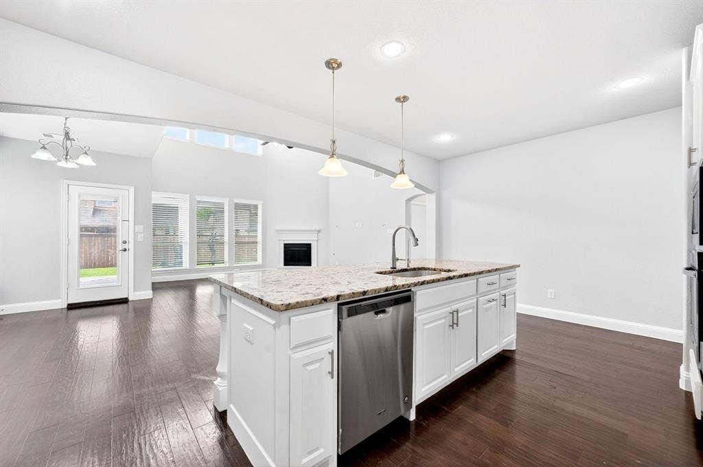Modern kitchen island featuring a stainless steel sink, gooseneck faucet, and white cabinetry with brushed nickel hardware
