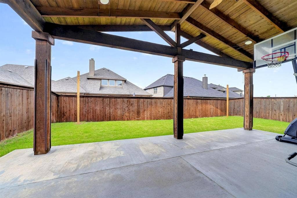 Covered patio featuring a wood-plank ceiling, exposed wood beams, and concrete flooring
