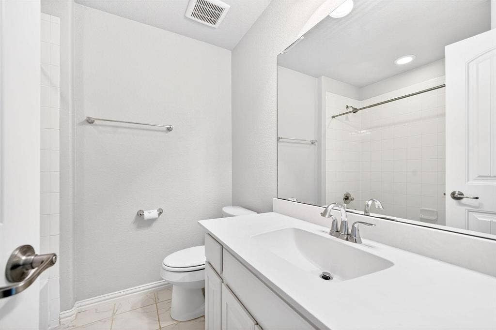 Bathroom featuring a white vanity with integrated sink, coordinating white countertops, and chrome fixtures