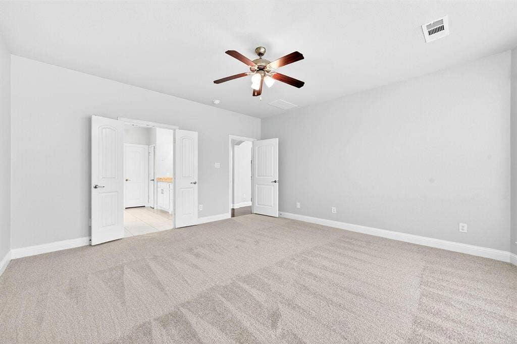 Spacious room featuring neutral carpeting and light gray walls