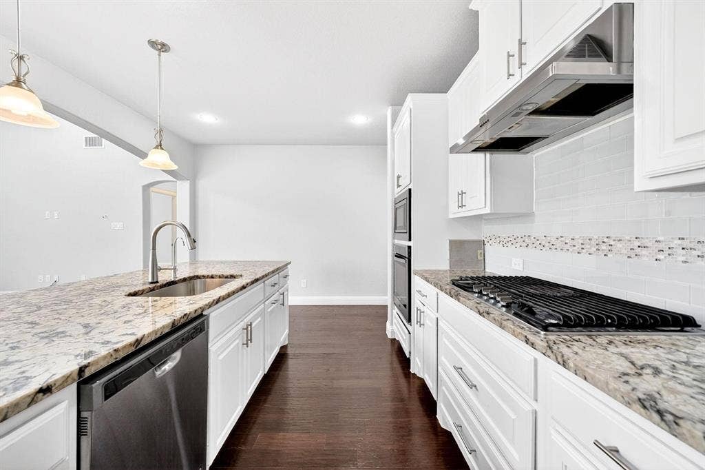 Gourmet kitchen featuring granite countertops, white cabinetry with brushed nickel hardware, stainless steel appliances, and wood-finish flooring