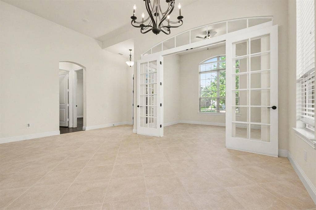 Dining Area leading to Study w French Doors.  Neutral paint throughout.