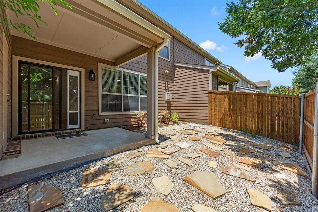 7916 Hannah Street, Plano, TX 75025 Private outdoor area featuring a concrete patio, gravel landscaping with irregular stone pavers, and a wood privacy fence
