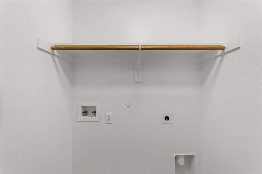 7916 Hannah Street, Plano, TX 75025 Dedicated laundry area featuring a wood-finish hanging rod, white shelving, water hookups, and electrical outlets