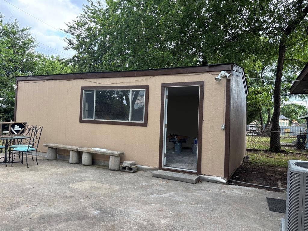 910 NE 31st, Grand Prairie, TX 75050 Detached structure with a tan exterior, brown trim, and a flat roof