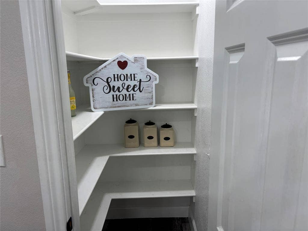 910 NE 31st, Grand Prairie, TX 75050 Walk-in pantry featuring white shelving and a paneled door