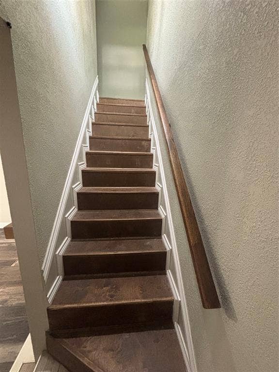 910 NE 31st, Grand Prairie, TX 75050 Staircase featuring wood-finish treads, white risers, and a dark wood-finish handrail