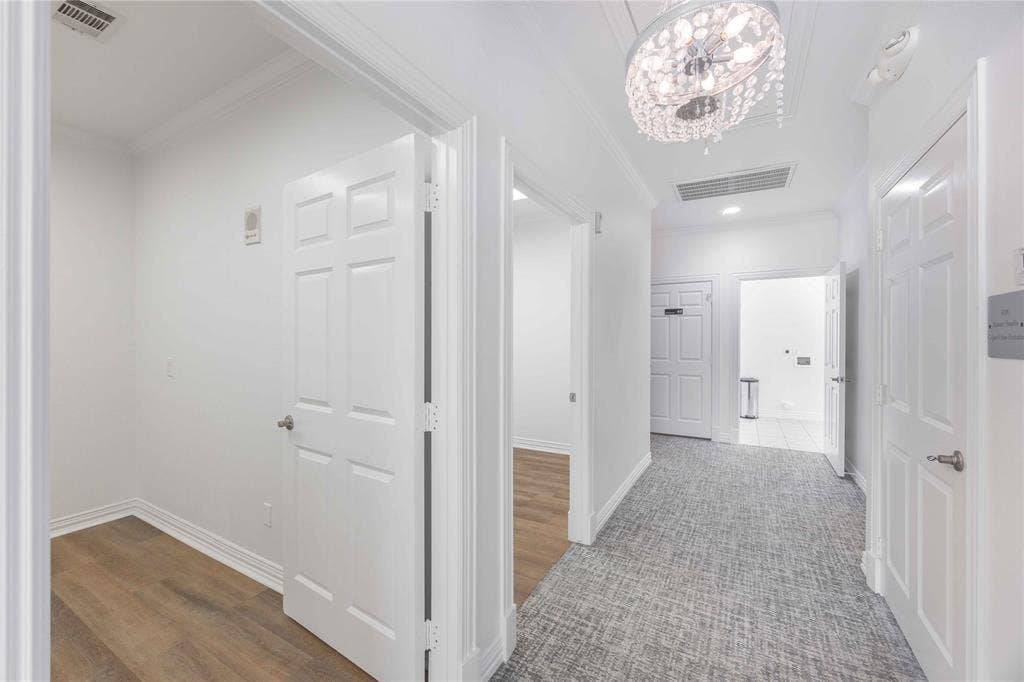 2840 Keller Springs Road, #1201, Carrollton, TX 75006 Hallway featuring a decorative chandelier, recessed lighting, crown molding, paneled doors, and carpeted flooring