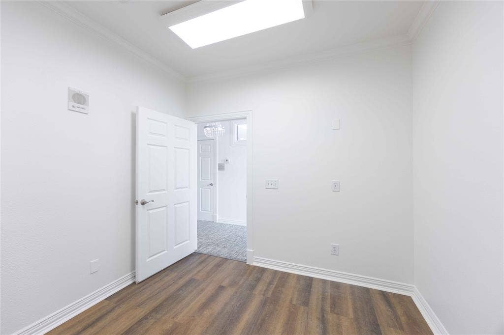 2840 Keller Springs Road, #1201, Carrollton, TX 75006 Wood-finish flooring, white paneled door, flush-mount lighting, and crown molding