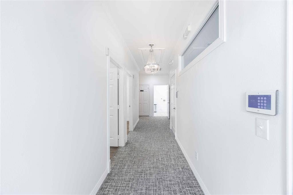 2840 Keller Springs Road, #1201, Carrollton, TX 75006 Hallway featuring white walls, patterned carpet, transom window, and a modern chandelier