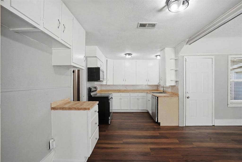 337 N 1st Street, Point, TX 75472 Kitchen featuring white cabinetry, wood-finish flooring, a stainless steel dishwasher, black range, and light-toned countertops