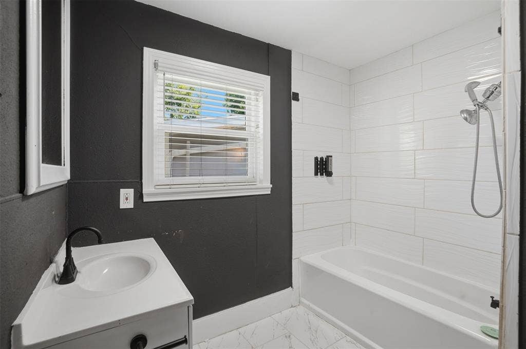 337 N 1st Street, Point, TX 75472 Bathroom featuring a white bathtub, white subway tile surround, white vanity with integrated sink, and matte black fixtures