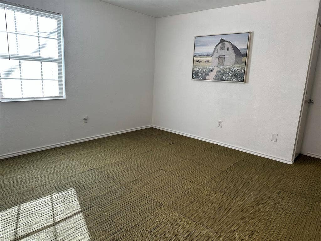 144 Huntoon Trail, Mabank, TX 75156 Interior room featuring an operable window with horizontal blinds, textured carpet flooring, white painted walls, and white baseboards