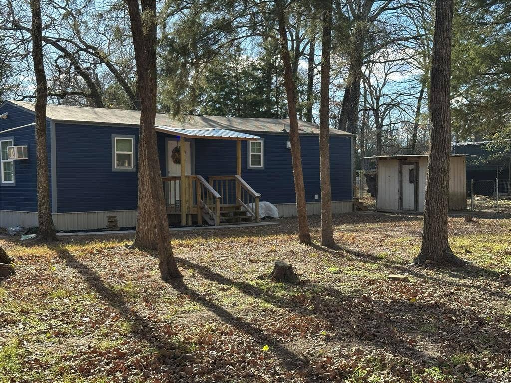 144 Huntoon Trail, Mabank, TX 75156 Blue siding home featuring a front porch with wood railings and steps, a covered entry, and multiple windows