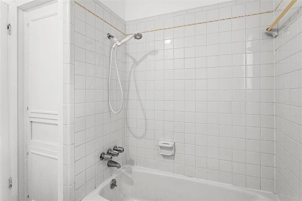 529 Georgetown Drive, Everman, TX 76140 White tiled shower surround with a handheld shower head