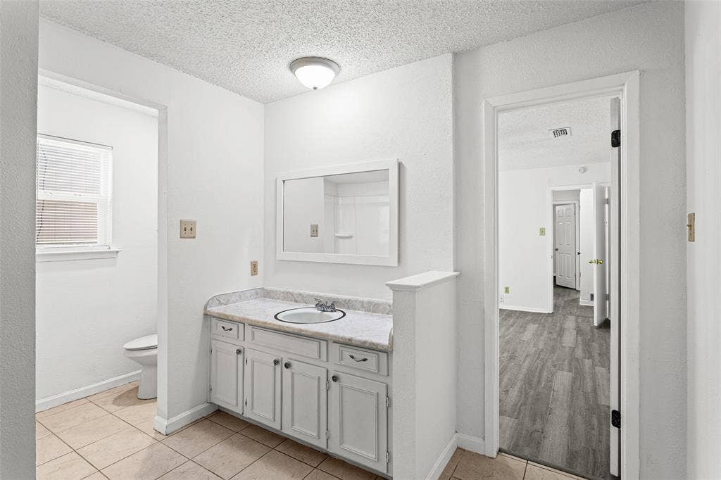 529 Georgetown Drive, Everman, TX 76140 Vanity with a light-toned countertop and white cabinetry