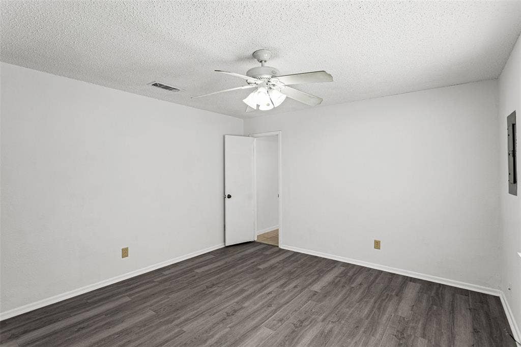 529 Georgetown Drive, Everman, TX 76140 Spacious room featuring wood-finish flooring, crisp white walls, and a ceiling fan with integrated lighting