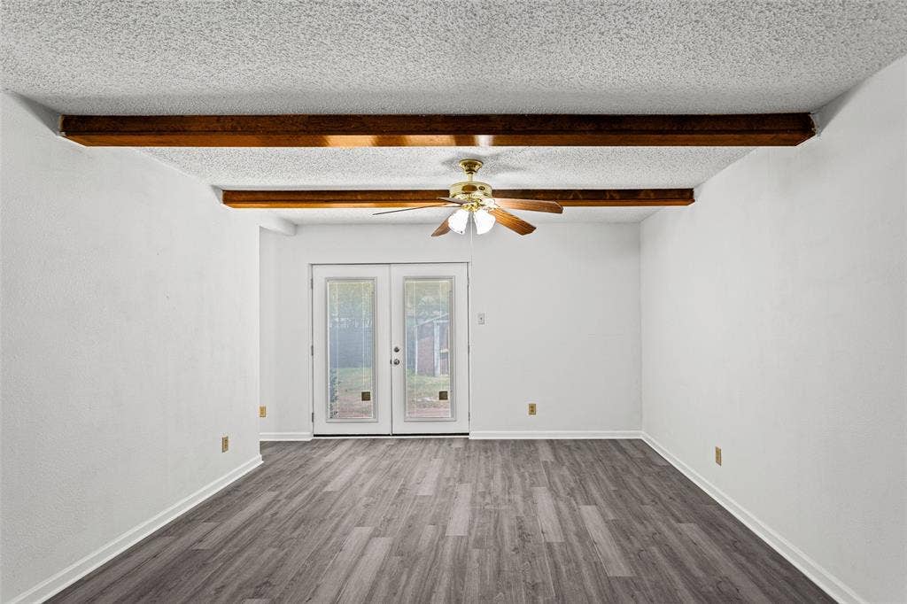 529 Georgetown Drive, Everman, TX 76140 Room featuring wood-finish flooring, exposed wood ceiling beams, a ceiling fan, and double glass-paned doors