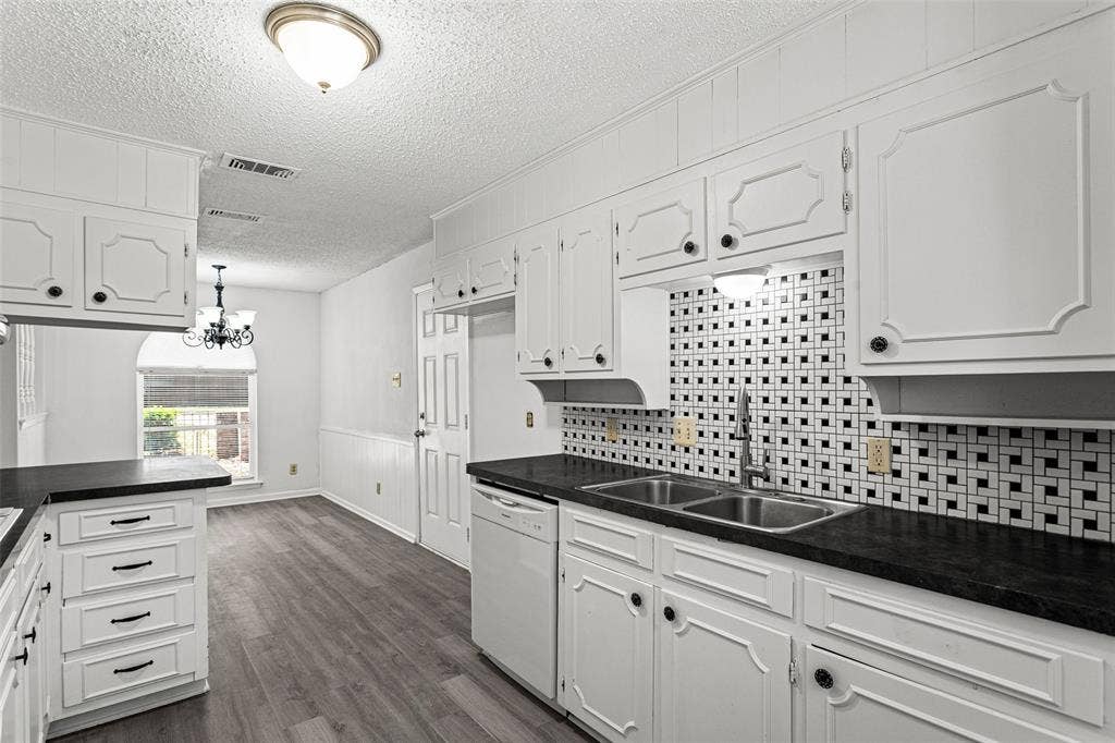 529 Georgetown Drive, Everman, TX 76140 Kitchen featuring white cabinetry, dark countertops, a mosaic tile backsplash, wood-finish flooring, and a stainless steel double basin sink