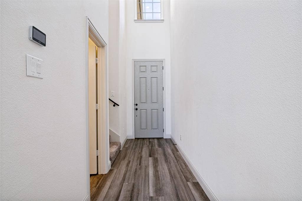 1006 Emil Place, Allen, TX 75013 Foyer featuring high ceilings, wood-finish flooring, a light gray paneled door, and an upper window providing natural illumination