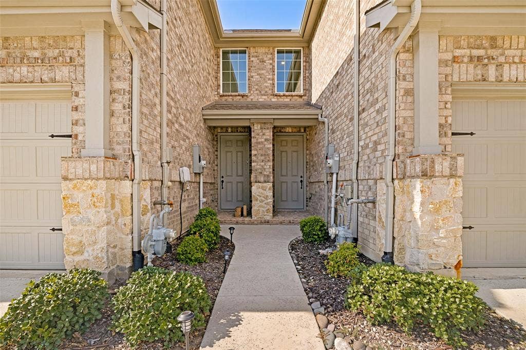 1006 Emil Place, Allen, TX 75013 Brick exterior with stone accents, featuring two individual entry doors and two garage doors